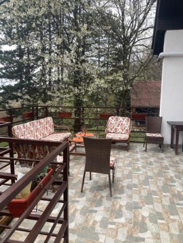 a patio with two chairs and a table and chairs at Kuca u sumi Kosmaj in Sopot