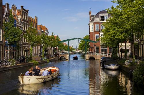 a group of people riding a boat down a canal at Hut-Spot, comfortabel houten tuinhuis in Oud-Ade