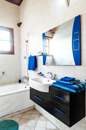 a bathroom with a sink and a tub and a mirror at Maison Ubururu in Kigali