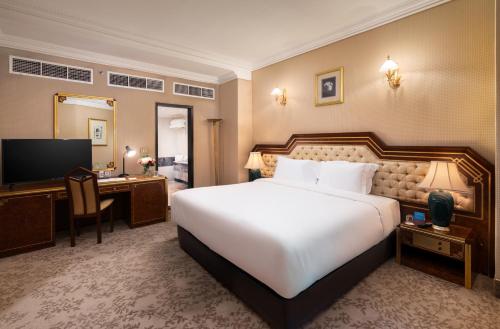 a hotel room with a large bed and a desk at Al Shohada by Palm Rich Makkah in Makkah