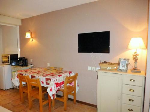 une salle à manger avec une table et une télévision murale dans l'établissement Charmant studio pour 4 pers. avec balcon, parking et wifi, à deux pas des Thermes et du centre village - FR-1-512-212, à Brides-les-Bains