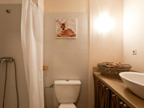 d'une salle de bains avec des toilettes et une photo d'un chien. dans l'établissement Charmant studio pour 4 pers. avec balcon, parking et wifi, à deux pas des Thermes et du centre village - FR-1-512-212, à Brides-les-Bains