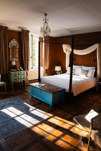 une chambre avec un lit à baldaquin et une table dans l'établissement LA MEFFRAIS 1741 Manoir d'hôtes aux portes de Dinan, à Dinan