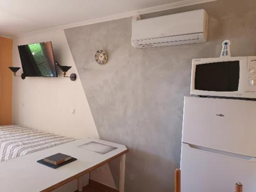 La cuisine est équipée d'un réfrigérateur blanc et d'un four micro-ondes. dans l'établissement le dramont, à Saint-Raphaël