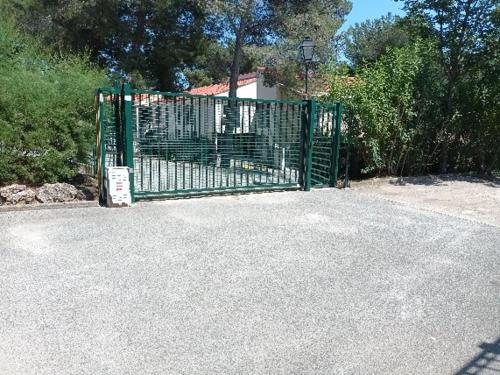 un portail vert avec un panneau devant lui dans l'établissement le dramont, à Saint-Raphaël