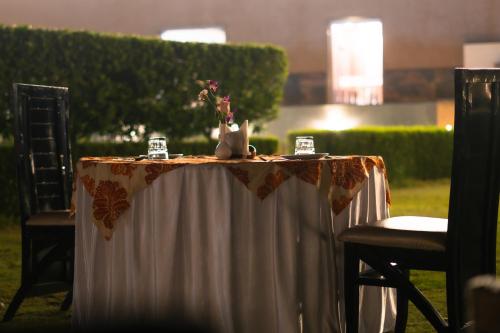 a table with a white table cloth and flowers on it at Imperia Resort by The Sky Imperial, Nathdwara in Nāthdwāra