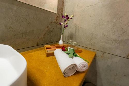 a table with towels and a vase with flowers at Imperia Resort by The Sky Imperial, Nathdwara in Nāthdwāra