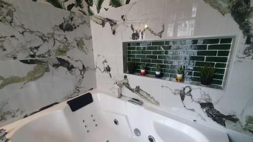 a bathroom with a white tub and a window at Loft Zen Rouen - Jacuzzi - Centre Historique in Rouen