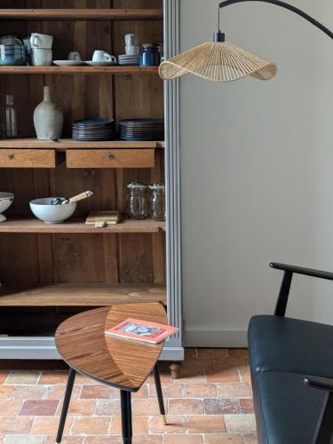 a table and a chair in front of a book shelf at La Sourcière Beaugency in Beaugency