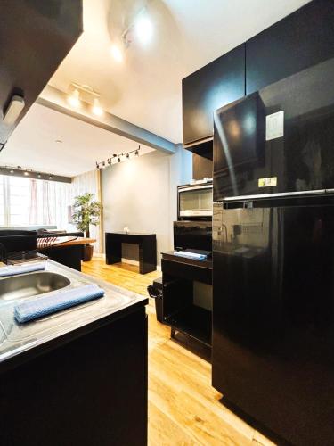 a kitchen with black cabinets and a black refrigerator at Apartamento Moderno em Copacabana in Rio de Janeiro