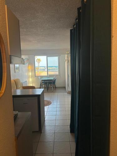 a kitchen and living room with a view of the ocean at Appartement front de mer in Le Barcarès