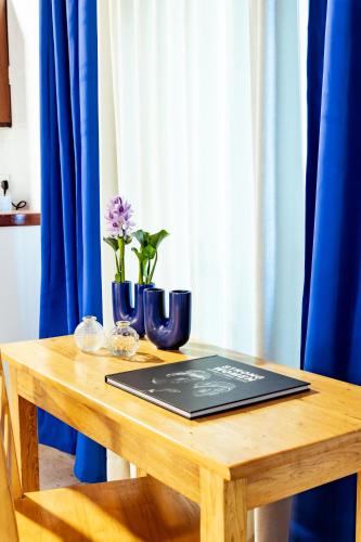 a wooden table with two blue vases on top of it at Maison Ubururu in Kigali