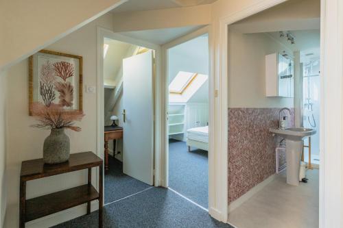 un couloir avec un lavabo et une salle de bains. dans l'établissement Résidence du Steir - T2, à Quimper