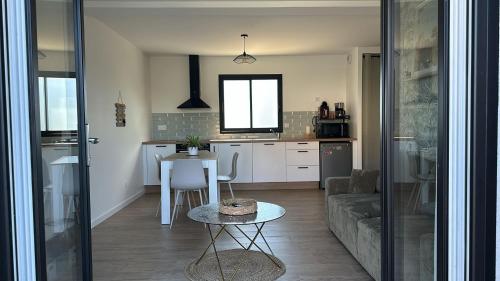 une cuisine et un salon avec une table et un canapé dans l'établissement Ti case, à Gonneville-en-Auge