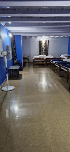 a room with benches and tables and a spotlight at Shambhavi Deepa gurusadhana guest house in Madikeri