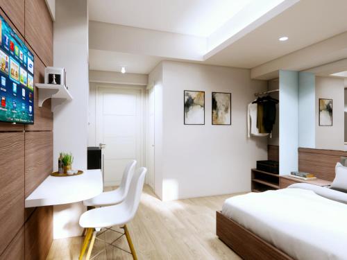 a bedroom with a bed and a desk and a tv at Cosmy Tanglin Apartment in Surabaya