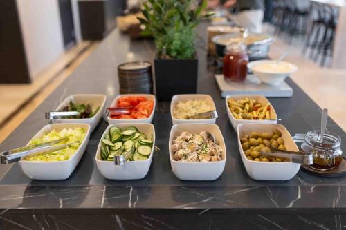 a table topped with trays of different types of food at Injoy Compact Hotel Solna in Solna