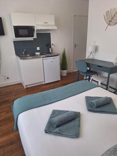 ein Zimmer mit Küche und Bett mit zwei Handtüchern in der Unterkunft L'Appel De La Forêt - Wifi Fibre, Linge & Parking in Châteaubriant