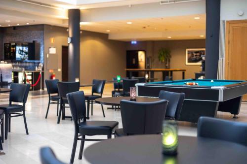 a restaurant with a pool table and tables and chairs at Injoy Compact Hotel Solna in Solna