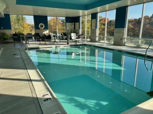 a large swimming pool with blue water in a building at Hampton Inn & Suites Deptford, Nj in Deptford
