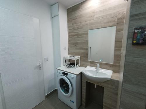 a bathroom with a washing machine and a sink at Pelso Holiday Apartments Jasmin in Siófok