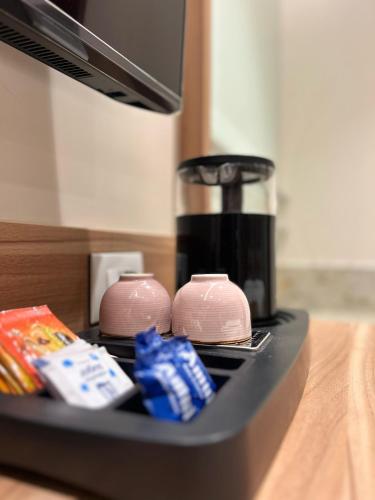 a counter with two pink bowls and a coffee maker at The Paradise Kingdom in Kanchipuram