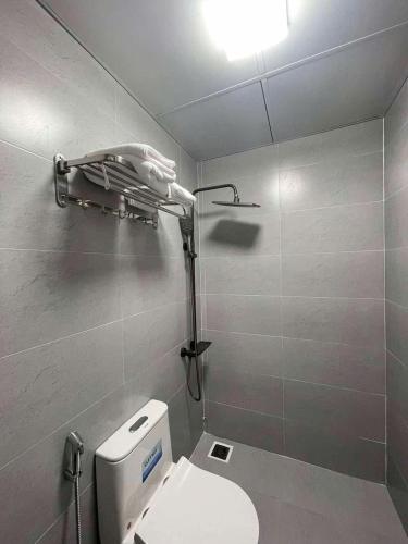 a bathroom with a toilet and a light on the wall at Nhà Shi Homestay in Hue