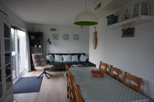 a living room with a couch and a table and chairs at Kustverhuur, Park Schoneveld, Zeester 38 in Breskens