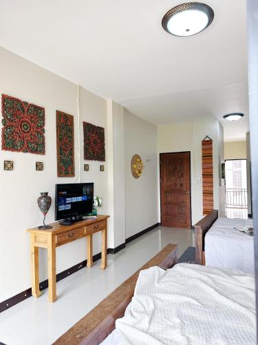 a bedroom with a bed and a television on a table at candy house ที่พักวัวลาย เชียงใหม่ in Chiang Mai