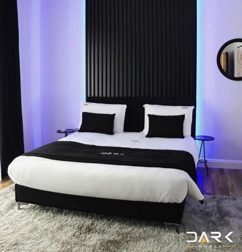 a bedroom with a large bed with black and white pillows at Dark Boutique Hotel in Tirana