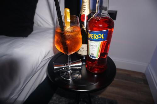 a table with a drink and a bottle of alcohol at Dark Boutique Hotel in Tirana