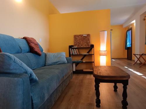 a living room with a blue couch and a table at Apartamento Rural La Frondosa in Villasbuenas de Gata