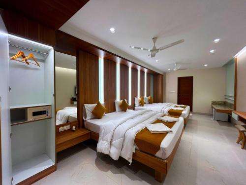 a large bedroom with two beds and a television at The Paradise Kingdom in Kanchipuram