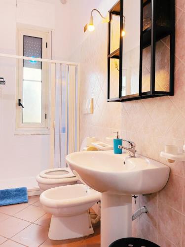 a bathroom with a sink and a toilet and a mirror at b&b L`Oasi in Casal Velino