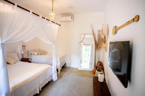 una camera da letto con due letti e una TV a schermo piatto di Casa Elbacha a Trancoso