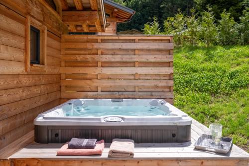 - un bain à remous dans l'arrière-cour d'une maison en bois dans l'établissement Chalet Seven Summits - Pool - Sauna - Jacuzzi - By Cozee Rentals, à Chamonix-Mont-Blanc