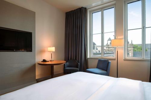 a hotel room with a bed and a table and chairs at Hilton Cologne in Cologne
