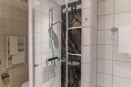 a shower with a glass door in a bathroom at Hilton Cologne in Cologne