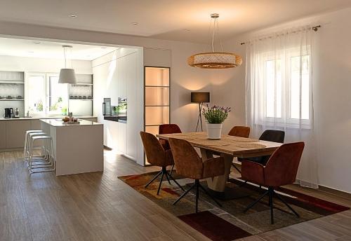 a kitchen and dining room with a table and chairs at Villa Kortus Luxury modern villa near Petram Resort, beach 700m and Adriatic golf resort in Savudrija