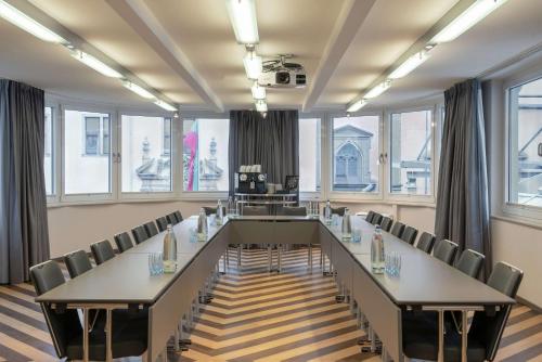 a large conference room with a long table and chairs at Hilton Cologne in Cologne