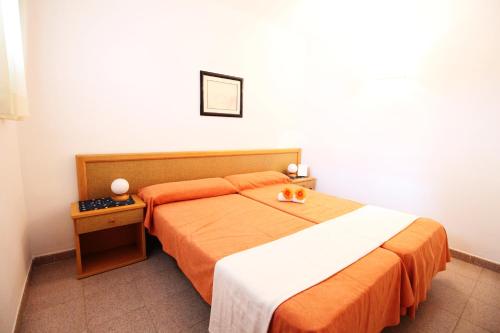 a bedroom with a bed with an orange and white blanket at Mariposa 1023 IBERPLAYA in Salou