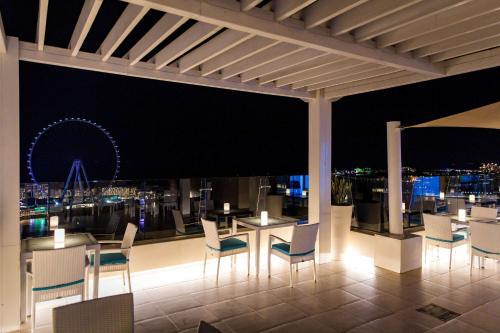a restaurant with a view of the city at night at Hilton Dubai The Walk in Dubai
