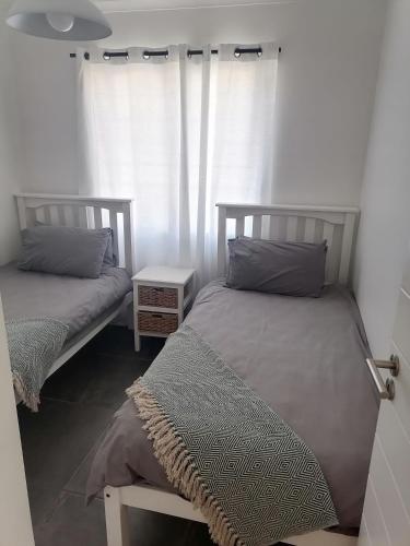 a bedroom with two beds and a window at Little Seacastle in Pearly Beach