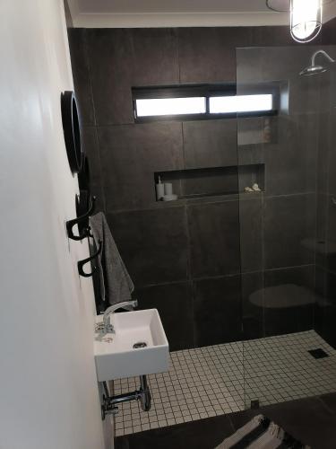 a bathroom with a sink and a shower at Little Seacastle in Pearly Beach