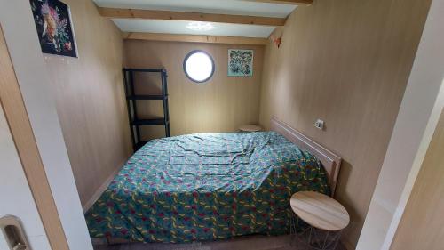 une petite pièce avec un lit et une fenêtre dans l'établissement Bateau solaire, à Castelfranc