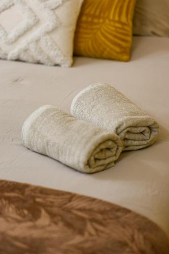 une pile de serviettes assises sur un lit dans l'établissement Le Refuge #200m François 1er, à Cognac