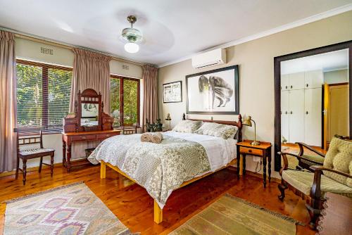 een slaapkamer met een bed, een tafel en een bank bij 5 on Paul Kruger in Somerset West