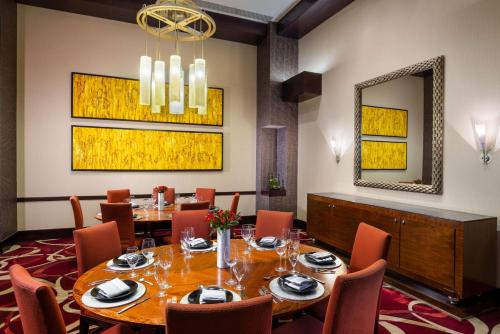 a dining room with a table and a mirror at Hilton Americas - Houston in Houston
