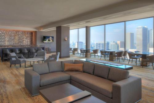 a living room with a couch and a bar with a view at Hilton Americas - Houston in Houston