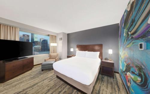 a hotel room with a bed and a flat screen tv at Hilton Americas - Houston in Houston